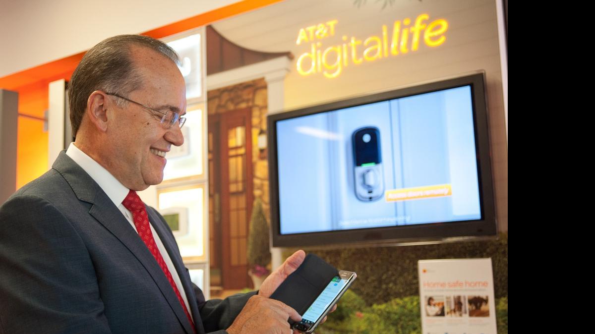 
Carlos Blanco, vice president and general manager for AT&T Florida, demonstrates how a porch light at his home can be controlled through his cell phone. 
