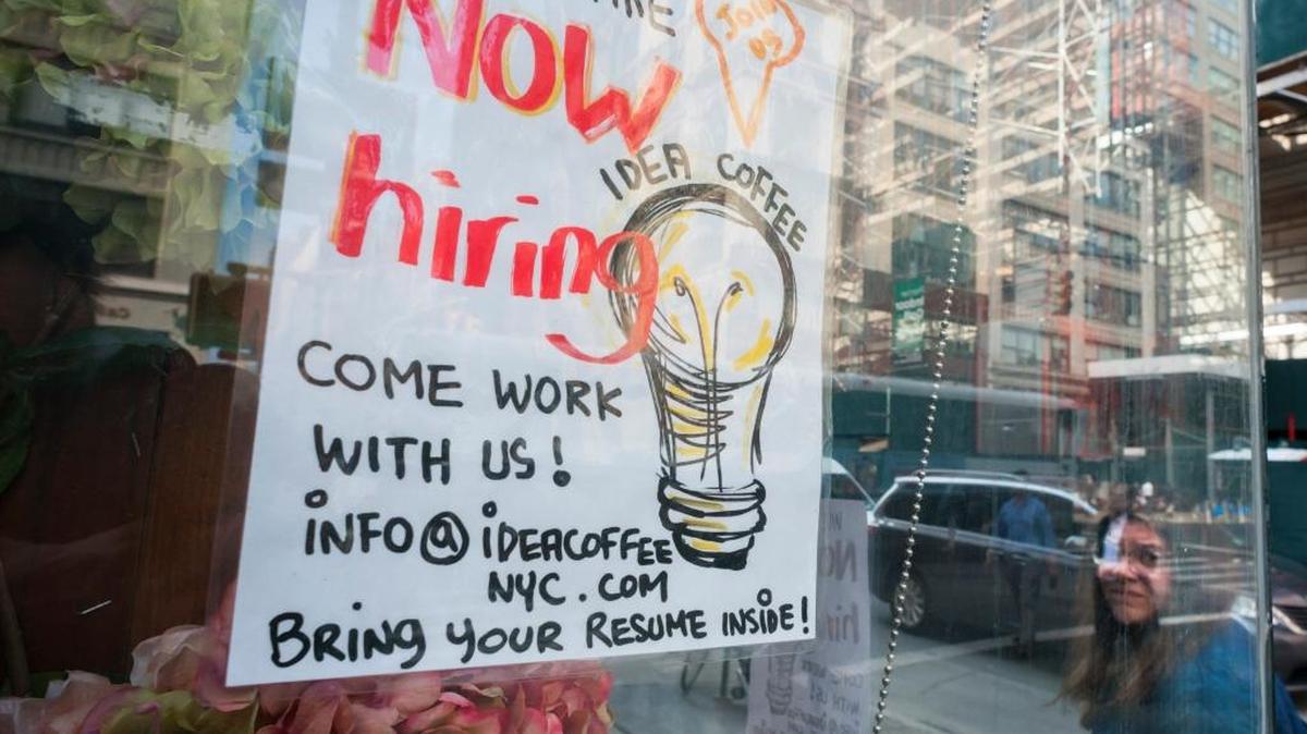 A sign in the window of a Idea Coffee in New York advertises for workers.