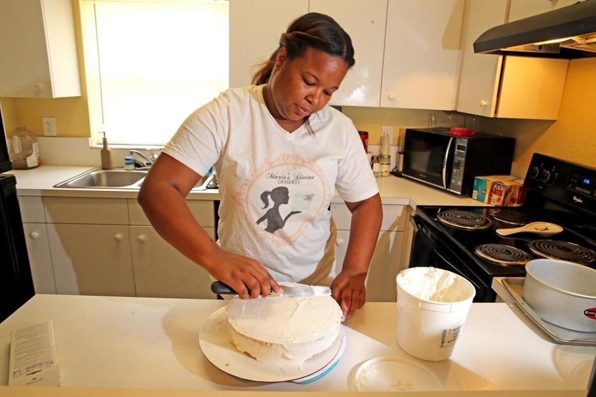 Marie Boone spreads icing on a cake in her Fort Lauderdale home, June 21, 2017. Boone of Marie’s Divine Desserts has built her own cake-and-dessert business, working out of her home. She uses mostly family recipes.