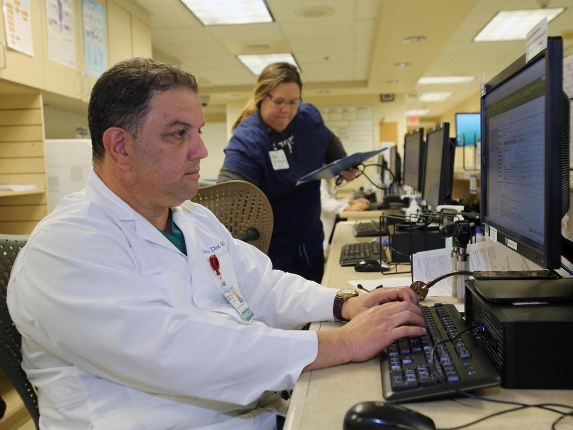 Dr. Lazaro Diaz works on a computer with Lori Carr at the Baptist Health Medical Plaza.