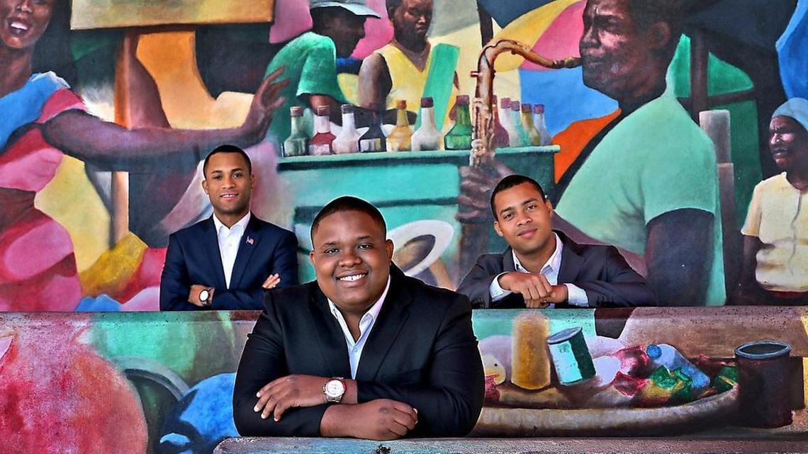 Steeve Simbert, left, friend Marc Estinville, center, and Steeve’s twin, Ally Simbert, co-founded Stopoint.com, which specializes in buying and selling used electronics. The trio of Haitian immigrants are shown in the courtyard of the Little Haiti Cultural Center.