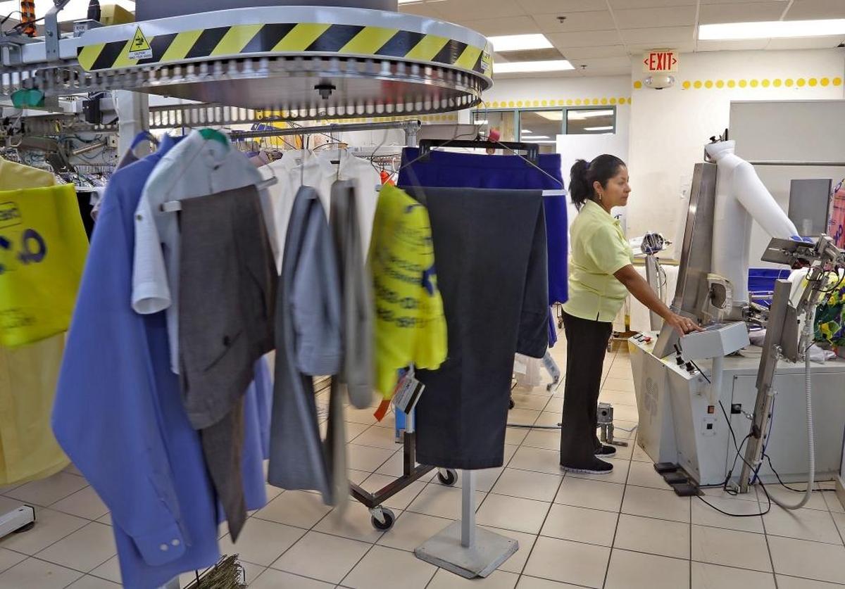 Maria Mejias, left, watches the shirt-ironing equipment at OXXO Care Cleaners in Hollywood.