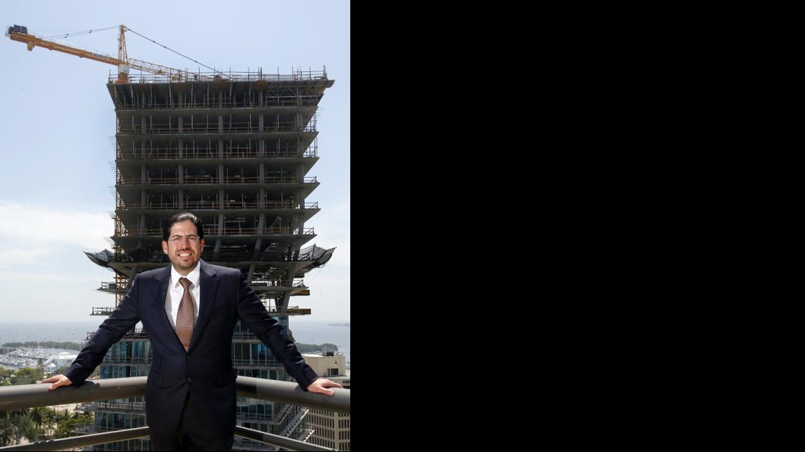 
Developer David Martin stands on a balcony at his office building in Coconut Grove with one twisting tower of his condo project, the Grove at Grand Bay, in the background.

