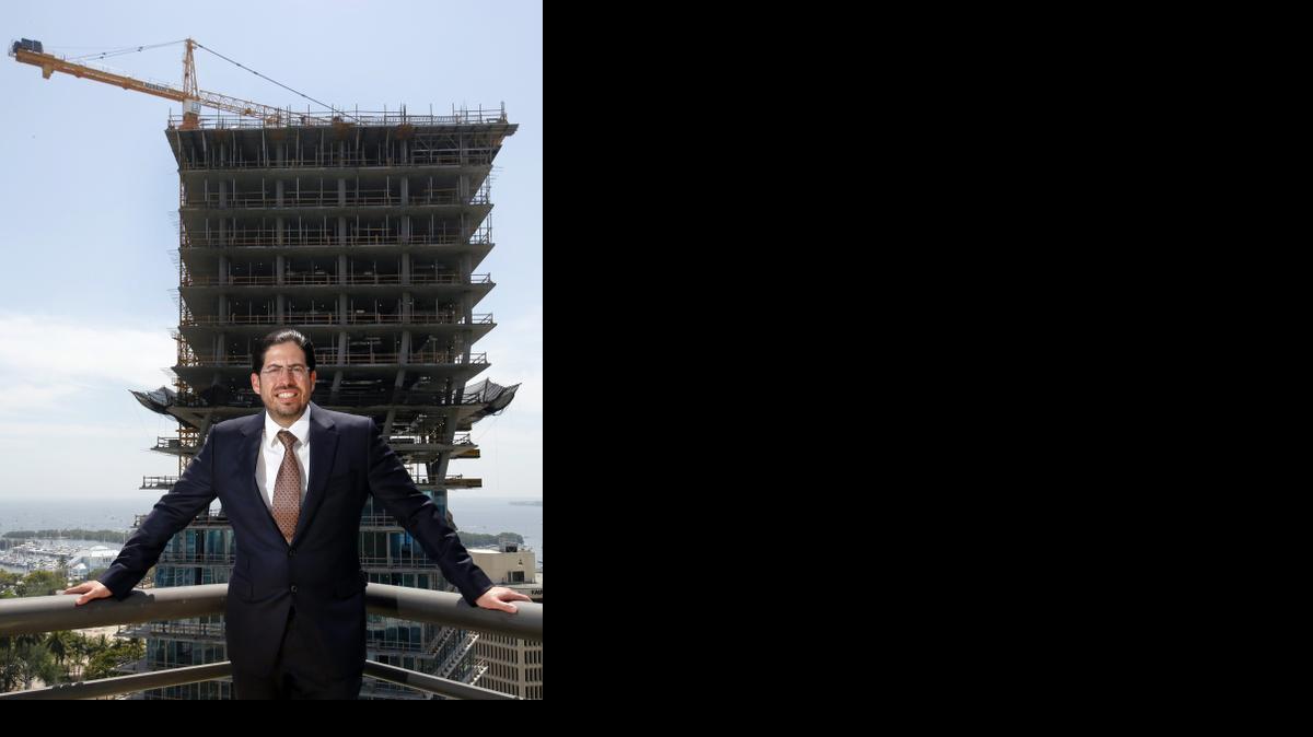 
Developer David Martin stands on a balcony at his office building in Coconut Grove with one twisting tower of his condo project, the Grove at Grand Bay, in the background.
