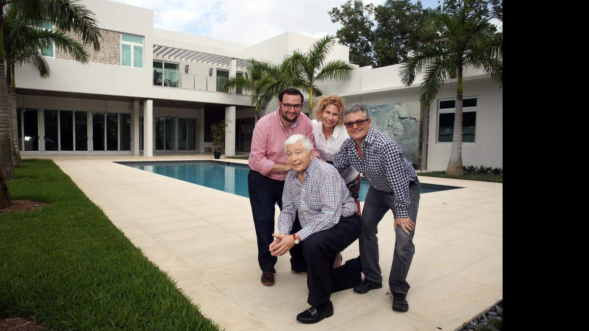 
FAMILY SUCCESS: Marvin Hollub ( kneeling), Aaron Hollub, Amy Marcus Hollub, and Harry Hollub (rear and standing), of Hollub Homes gather at an $8.45 million custom home they built in Coral Gables.
