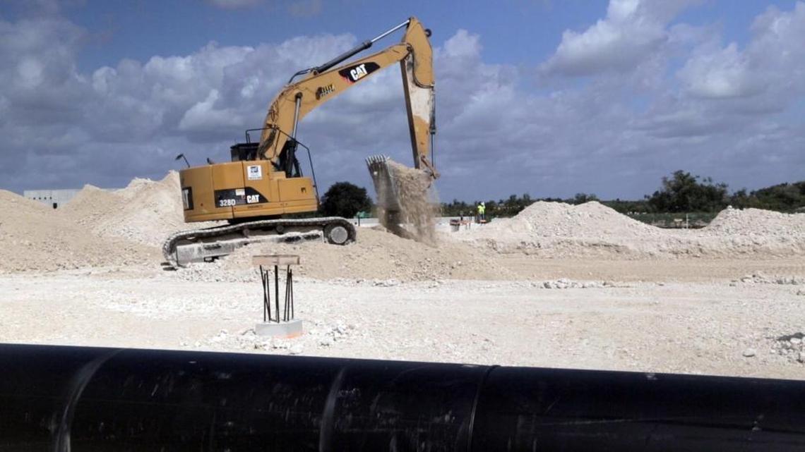 A backhoe digs a trench for pipes at the construction site in South Miami-Date County. Atlantic Sapphire, a world leader in land-raised salmon farming, is building a massive construction project.