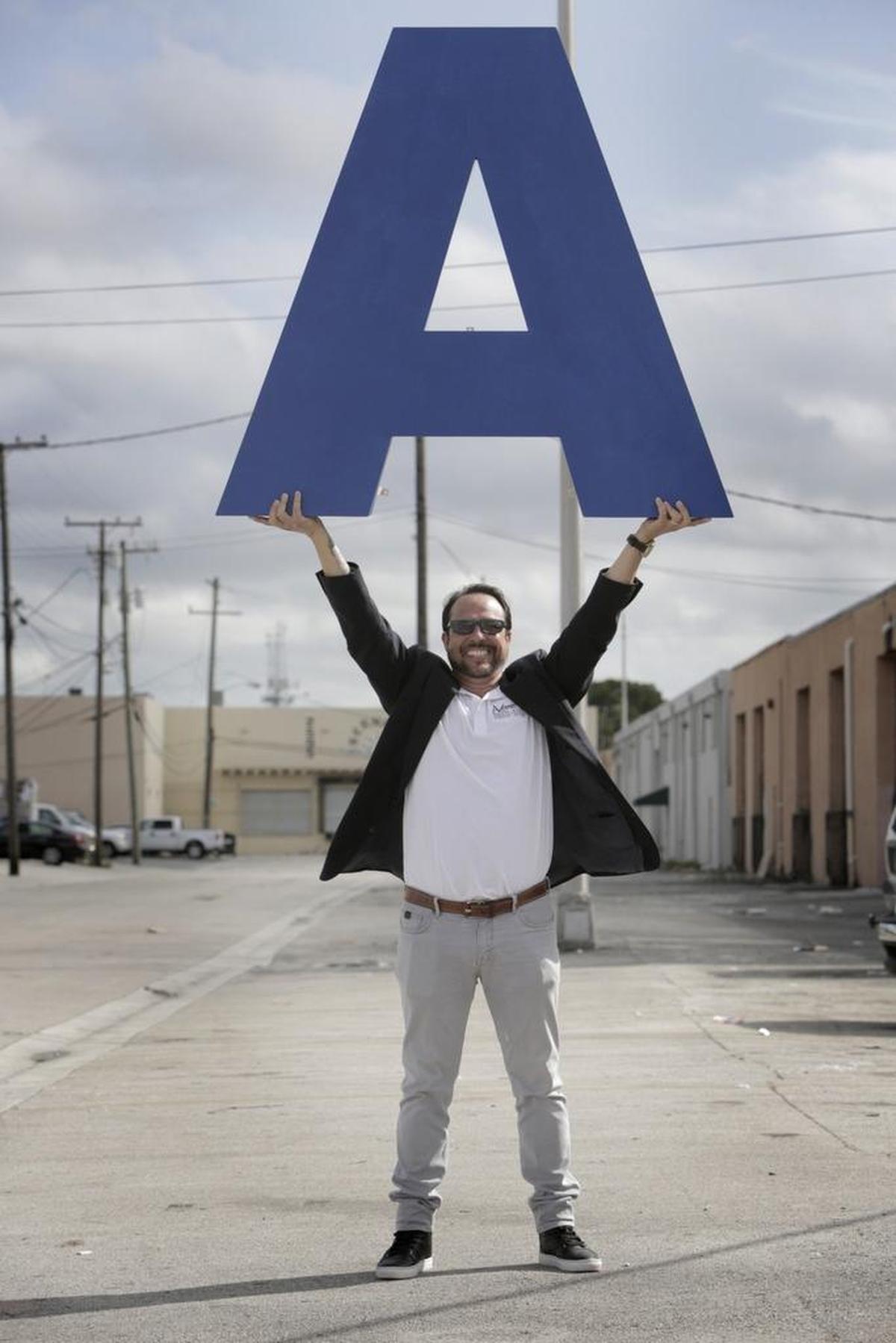 Ariel Pedrosa holds up a letter in front of his offices in Hialeah.