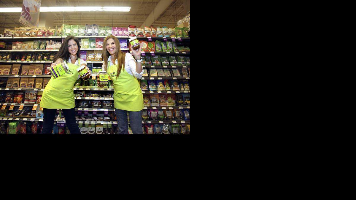 
ON THE SHELF: SuperFuzion co-founders Alyssa Fernandez-Isla, left, and Jacqueline Gadala- Maria playfully display their products at the Whole Foods Market in Coral Gables. 
