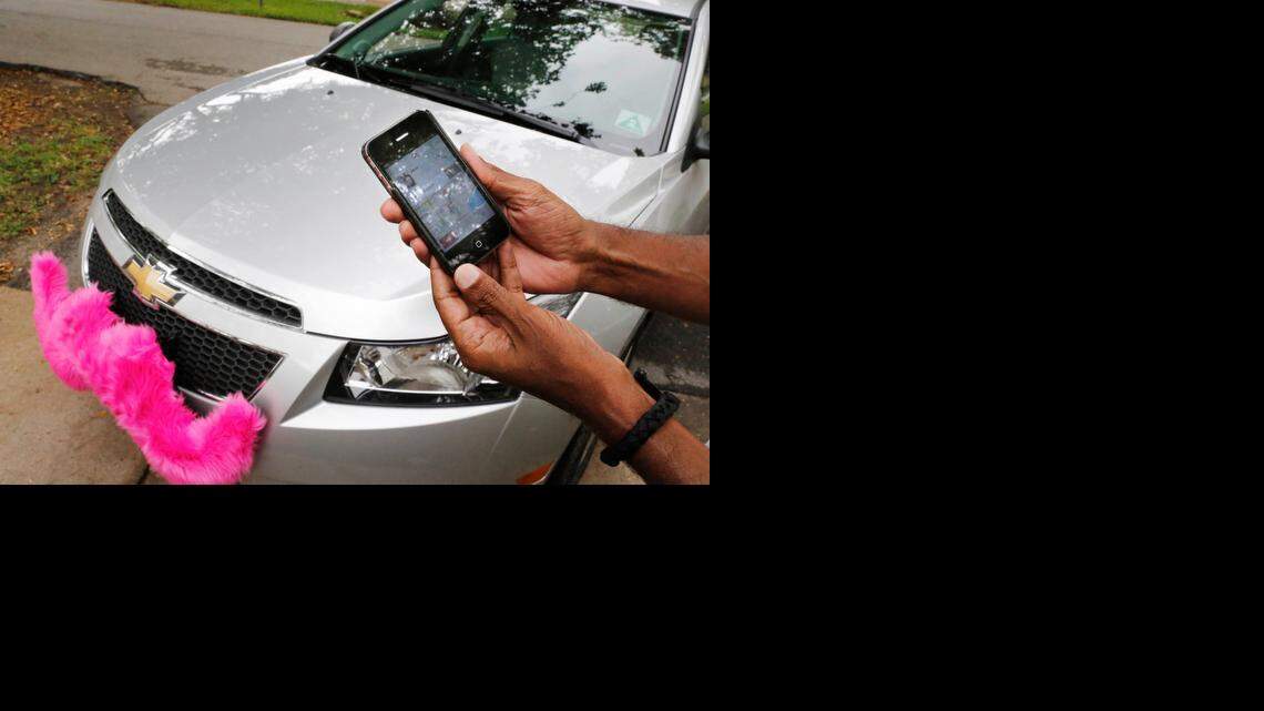 
CAR AT YOUR SERVICE: A Lyft driver closes out a trip on his smart phone. Lyft started service in Miami in late May.
