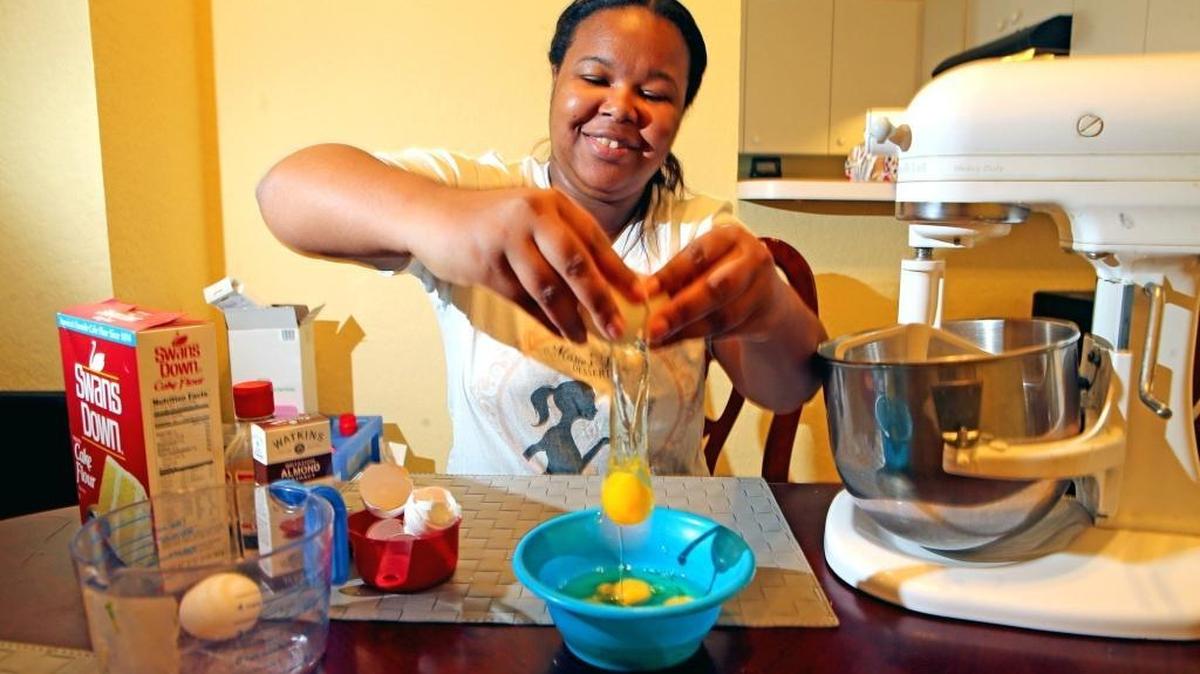 Marie Boone cracks an egg as she prepares to cook in her Fort Lauderdale home, June 21, 2017. Boone of Marie’s Divine Desserts has built her own cake-and-dessert business, working out of her home. She uses mostly family recipes.