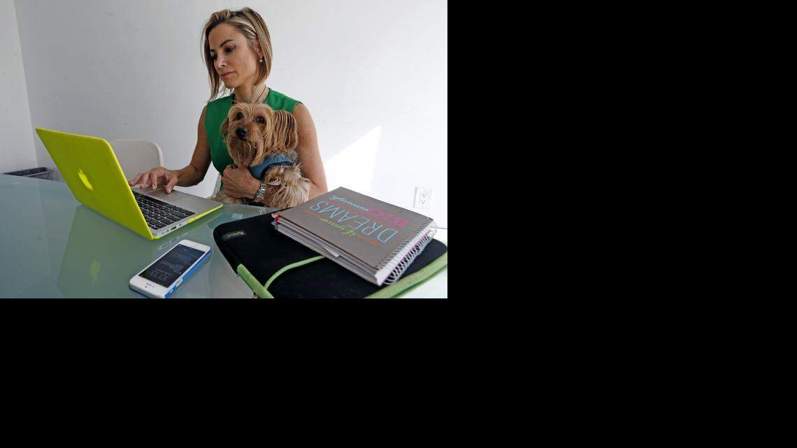 
WORLD AT HER FINGERTIPS: Silvina Moschini, who runs Yandiki, works while holding her dog John John in The LAB Miami in Wynwood. She runs Yandiki, which screens and matches tech talent, for instance in Latin America, with companies that need it. The site allows talent to live anywhere yet still find work online.


