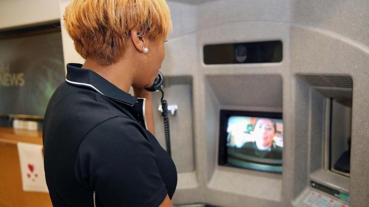 A teller talks to a customer at a Power financial Credit Union branch in Pembroke Pines through the visual ATM earlier this month. The customer can also see the teller on the video screen.