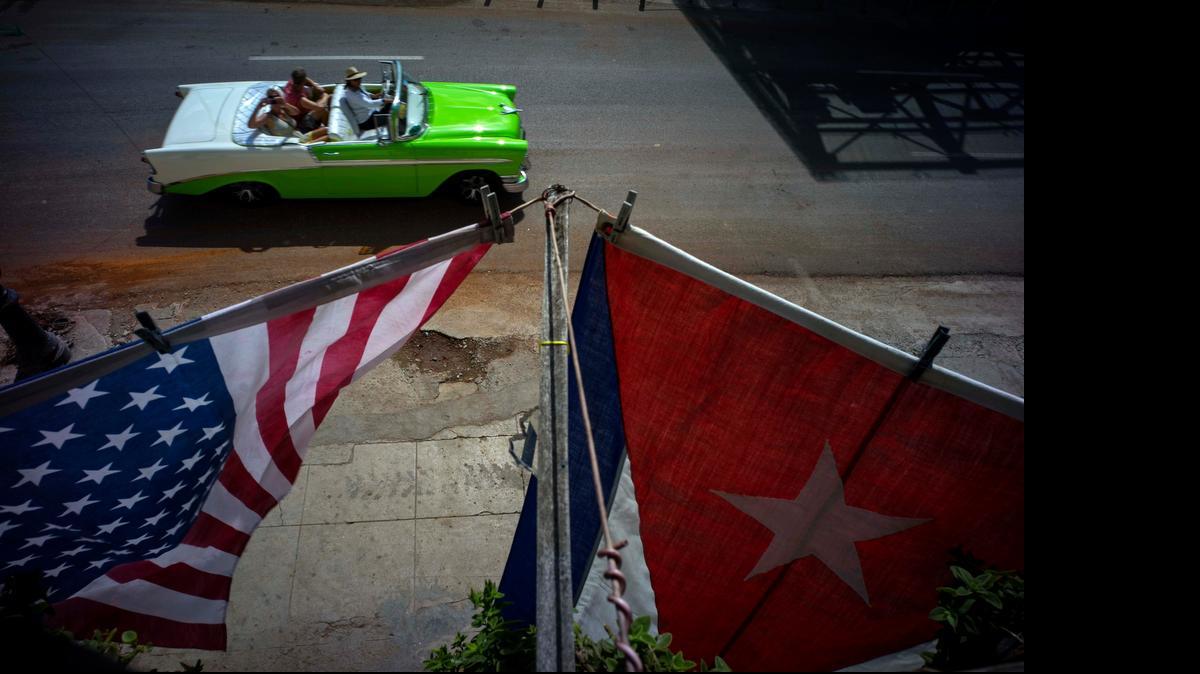 
A U.S., and a Cuban national flag, hang from a balcony to mark the restored full diplomatic relations between Cuba and the Unites States, in Old Havana, Monday, July 20, 2015. The new era began with little fanfare when an agreement between the two nations to resume normal ties on July 20 came into force just after midnight Sunday and the diplomatic missions of each country were upgraded from interests sections to embassies.

