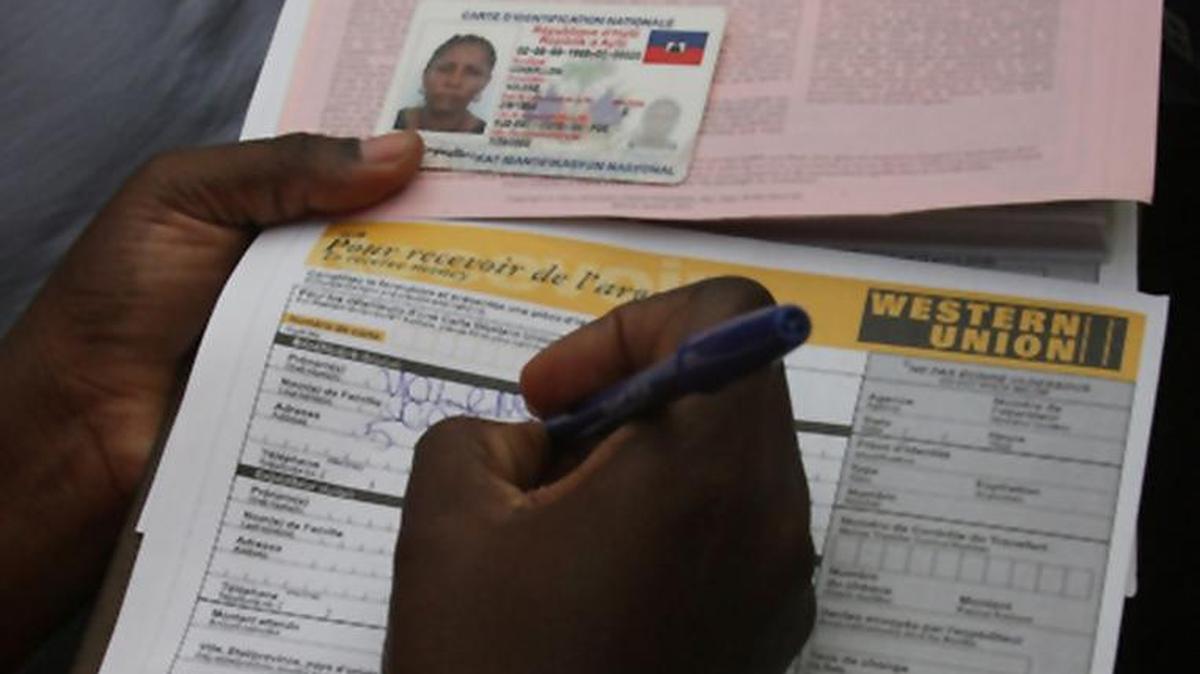 A Western Union employee fills out paperwork for a money transfer.