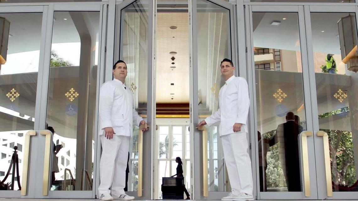 Porters Yandy Lopez, left, 41, and Felix Alpizar, 38, hold the door for guests as they enter the signature lobby space of the Faena Hotel which opened in 2015.