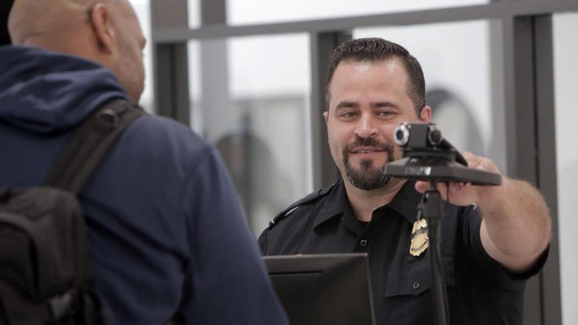 Agent Hernandez of U.S. Customs and Border Protection prepares to use MIA’s new facial recognition technology on a newly arrived passenger to Miami International Airport. The airport unveiled its refurbished Concourse E, which offers facial recognition technology for international arrivals.