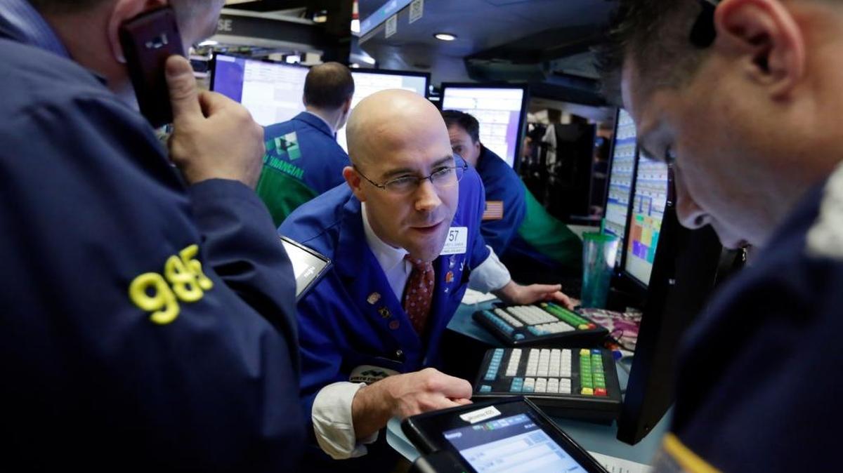Specialist Jarret Johnson, center, works at his post on the floor of the New York Stock Exchange, Friday, March 18, 2016. U.S. stocks opened higher again, setting the market up to extend its winning streak to a fifth week and erasing most of the year’s early losses.