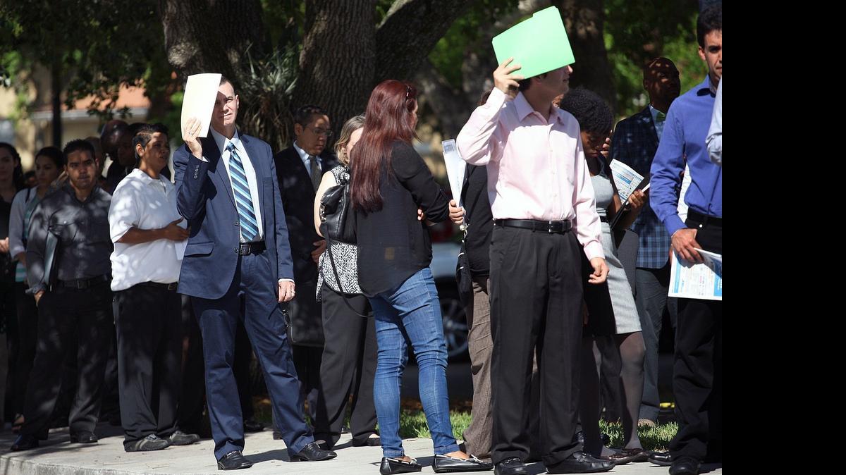 
Job seekers line up outside the Shula Hotel & Golf Resort for a job fair in Miami Lakes last month.
