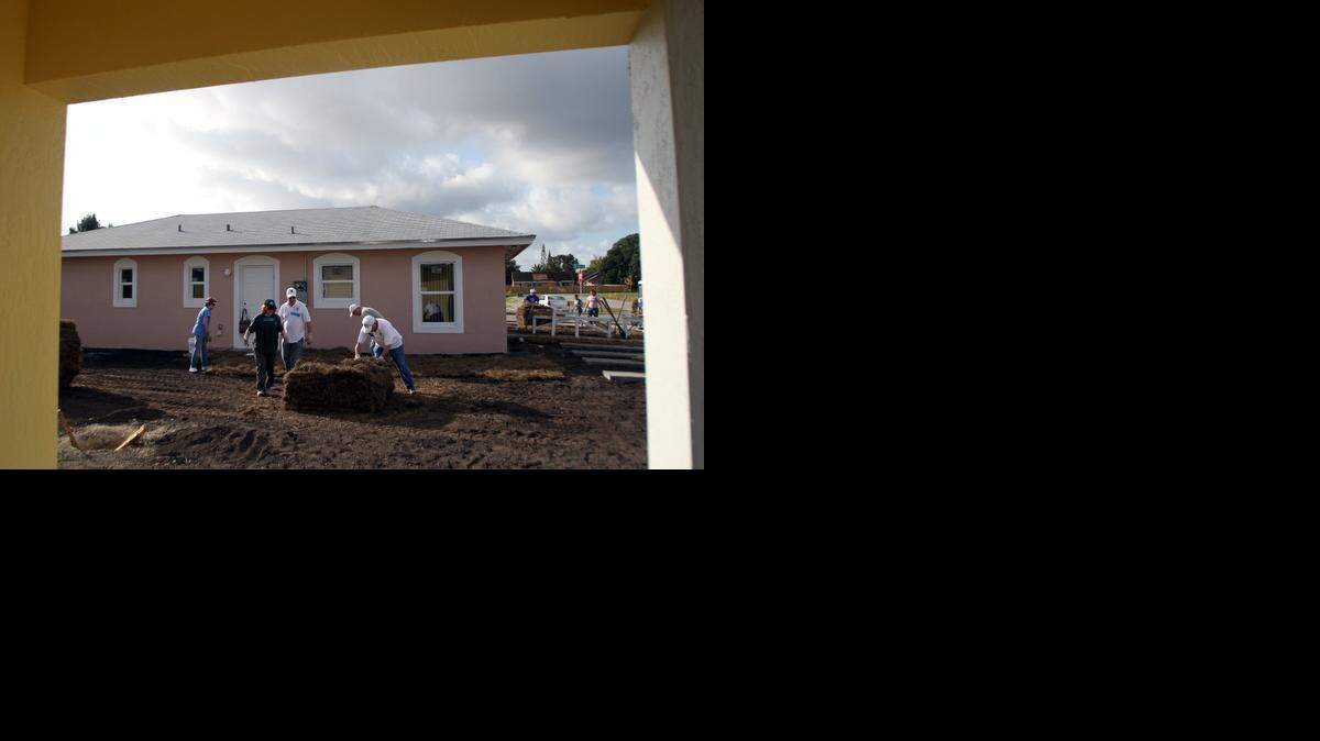 
Members of the Knights of Columbus and the Columbiettes landscape new homes in South Miami Heights during a Habitat for Humanity event to build affordable housing in 2013.
