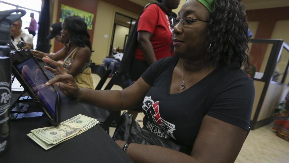 Donna Bascombe opens a bank account for her one-year-old grandson Isaiah Bascombe during a #BankBlack Movement event at OneUnited Bank in West Little River on Saturday, July 30, 2016.
