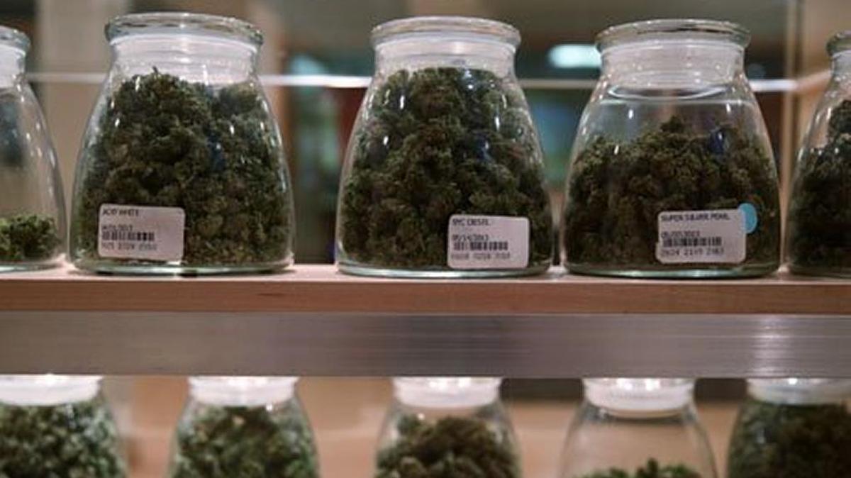 Jars containing various strands of medical marijuana sit behind a display case at the River Rock Medical Marijuana Center in Denver, in 2013.