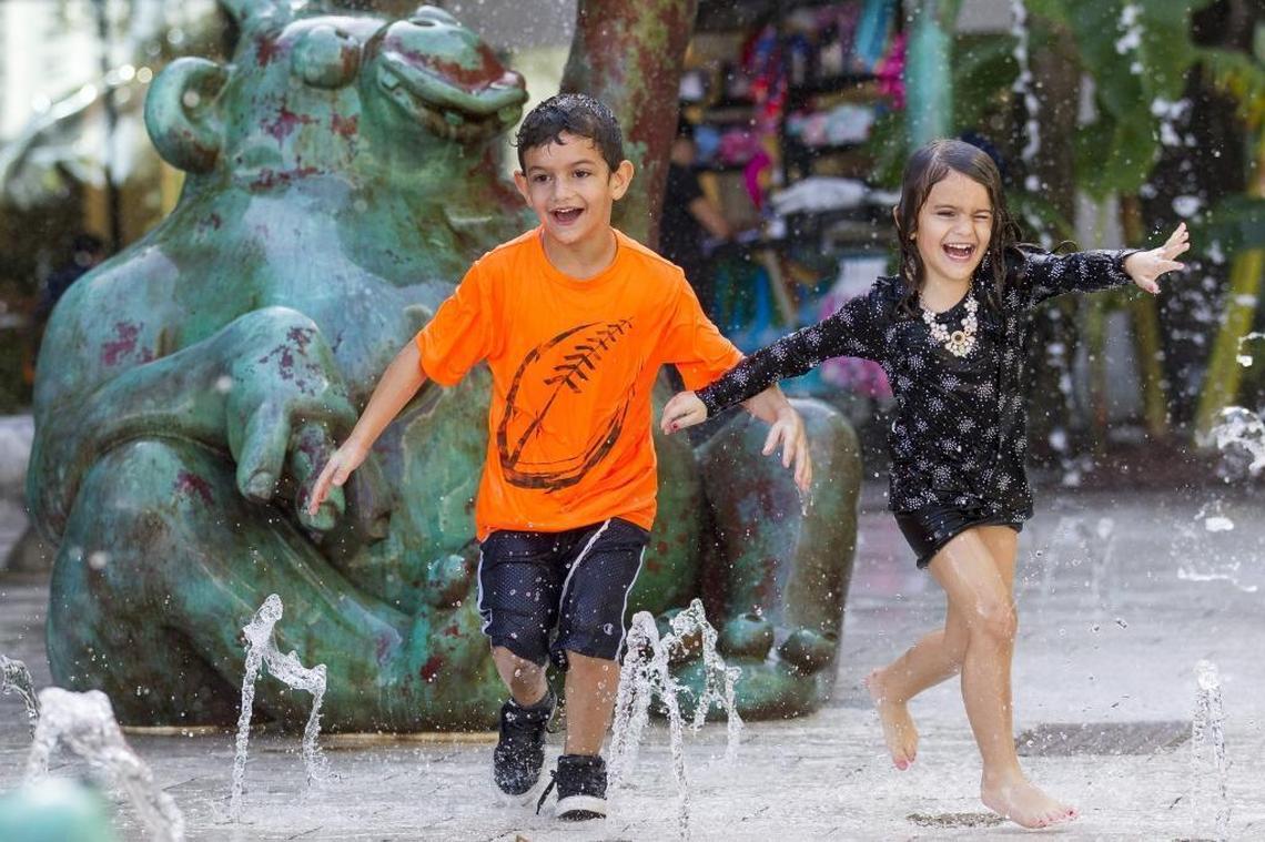 Aryeh Avissar, 6, and his sister, Yaelle Avissar, 4, run through a newly installed outdoor fountain at Aventura Mall on Monday, Dec. 18, 2017. The fountain, "Gorillas In The Mist," includes three bronze gorillas and four bronze trees shooting water. It was added to the mall as part of a three-story wing expansion, which brings new restaurants, retail stores and a 93-foot-tall slide.