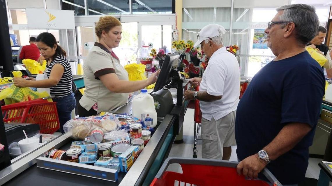 Pedro Garcia, right, purchases necessities prior to Hurricane Irma, including water, saltines, cans of tuna and some canned products at the Sedanos Supermarket on Eighth Street and 48th Avenue on September 5, 2017.