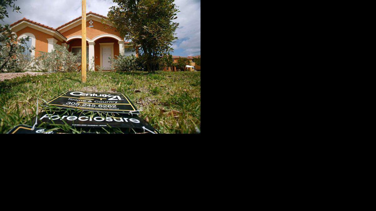 
A “for sale” sign lies on the ground in front of a foreclosed home in Homestead in 2009. 
