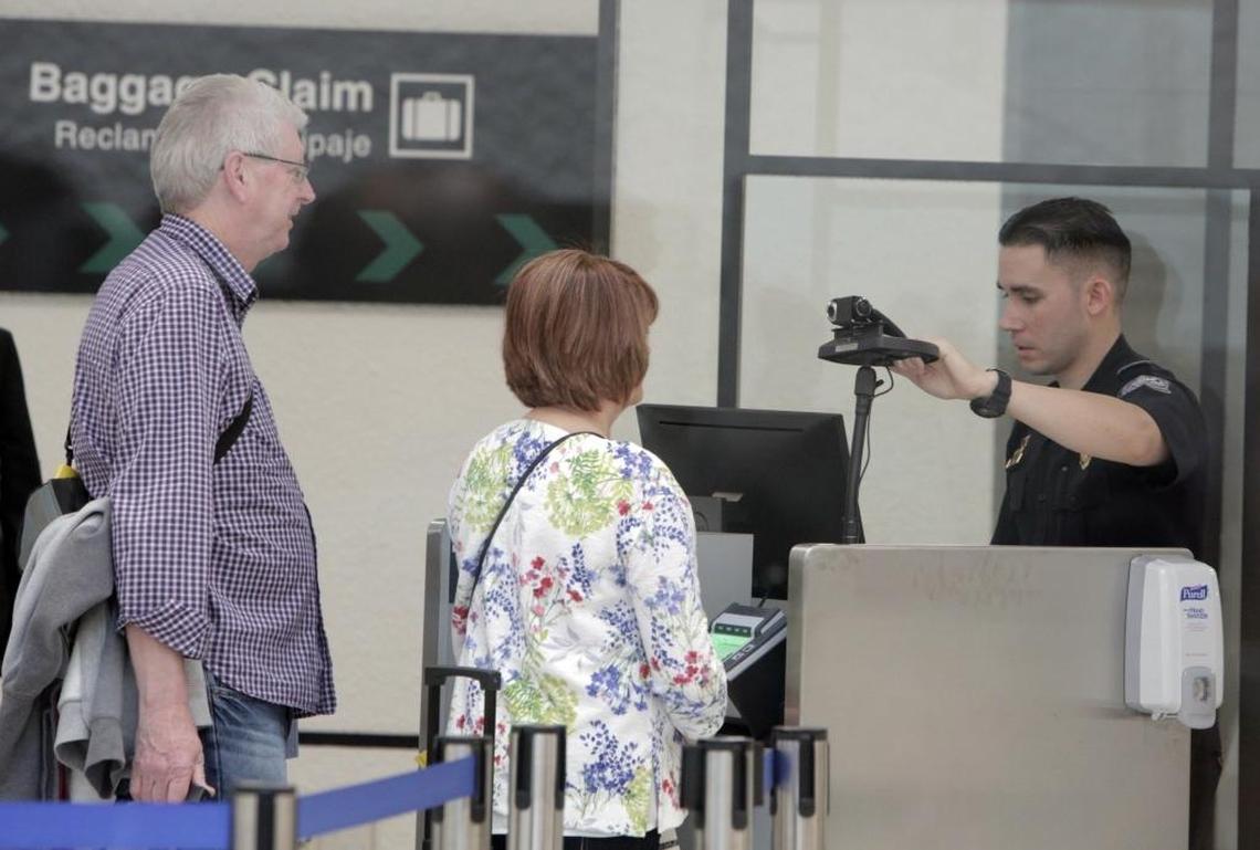 An agent of U.S. Customs and Border Protection prepares to use Miami International Airport’s new facial recognition technology on newly arrived passengers to MIA on Feb. 27, 2018.