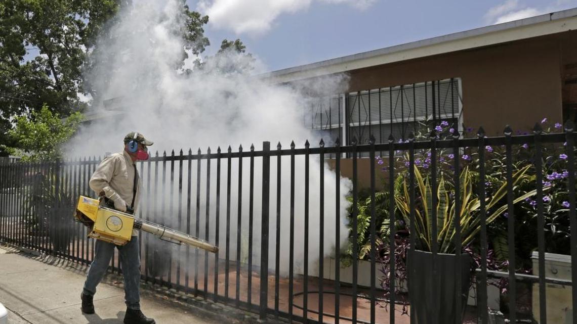 A Miami-Dade County mosquito control worker sprays around a home in the Wynwood area of Miami on Monday, Aug. 1, 2016. The CDC has issued a new advisory that says pregnant women should not travel a Zika-stricken part of Miami, and pregnant women who live there should take steps to prevent mosquito bites and sexual spread of the virus.