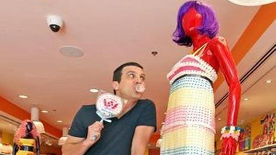 Jeff Rubin, the gum-popping president and CEO of IT’SUGAR, strikes a pose near a mannequin in a candy dress and an array of other colorful products for kids. 2014 PHOTO BY CHARLES TRAINOR JR. / MIAMI HERALD