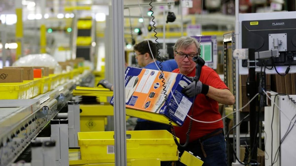 Mark Oldenburg processes outgoing orders, Monday, Nov. 30, 2015, at Amazon.com’s fulfillment center in DuPont, Wash.