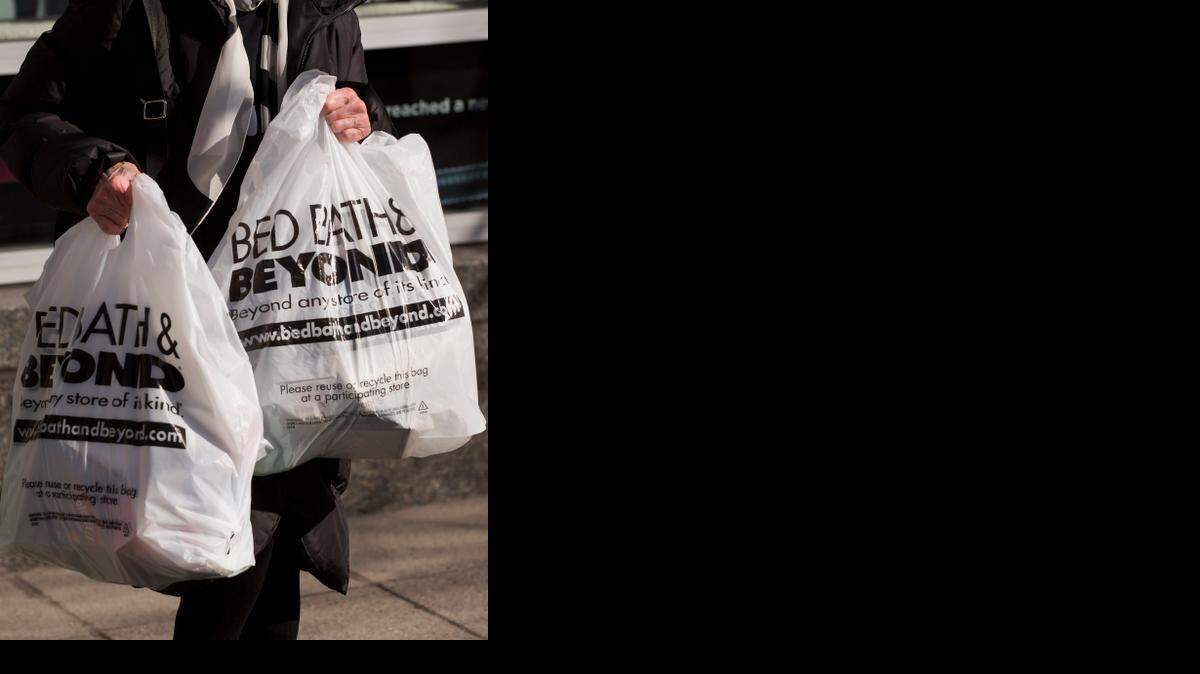 
A customer holds shopping bags while exiting a Bed Bath & Beyond Inc. store in New York.

