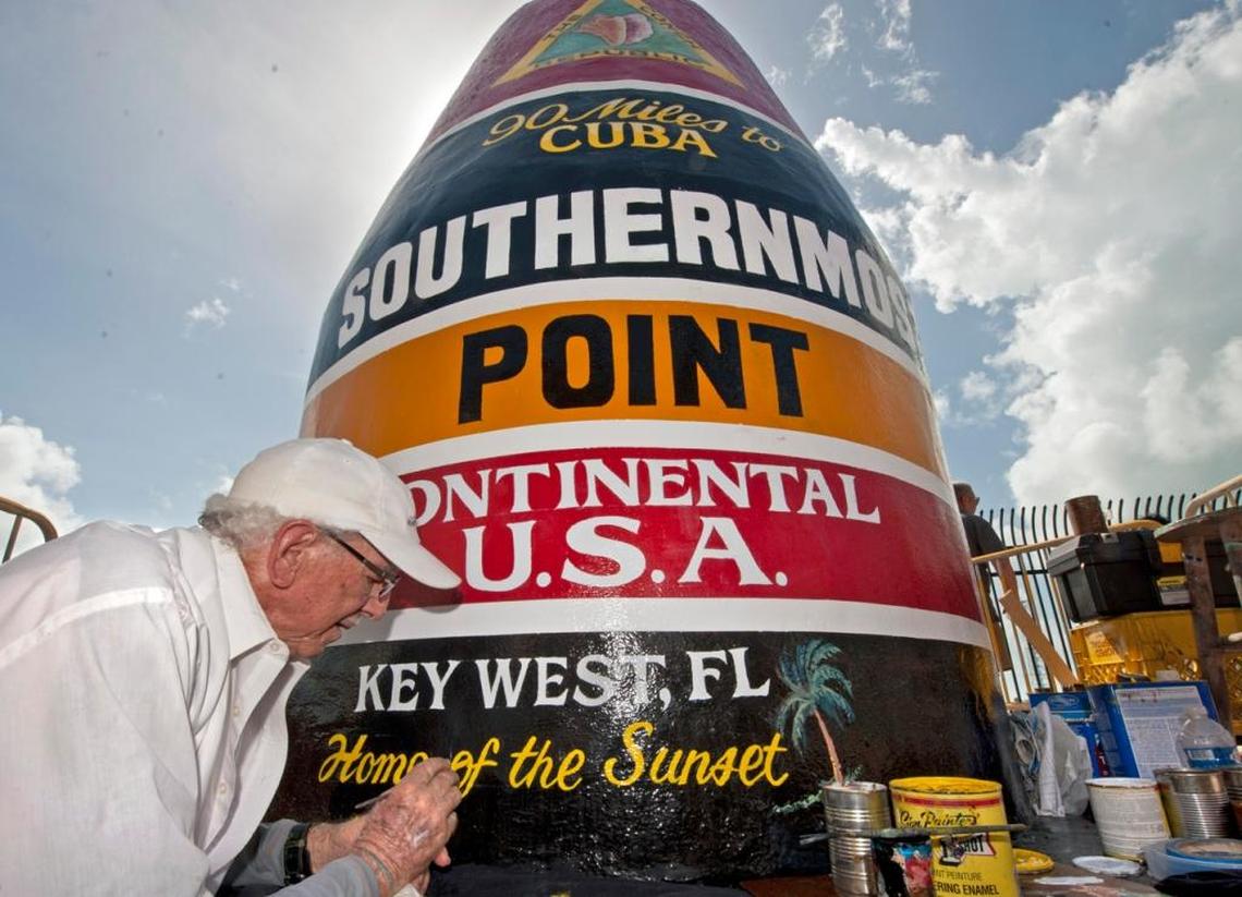 Artist Danny Acosta completes lettering the Southernmost Point in the Continental U.S. marker Monday, Oct. 23, 2017, in Key West, Fla. One of the most-photographed tourism icons in the Florida Keys was pummeled by Hurricane Irma on Sept. 10, 2017, stripping most of the paint and a large chunk of stucco. The concrete structure stands 10 feet high and weighs 4 tons.
