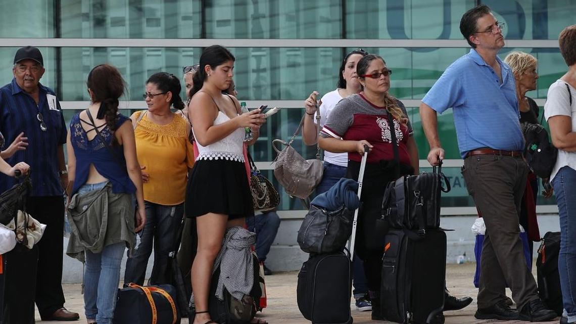 People wait in line to get a flight out of the Luis Munoz Marin International Airport as they try to return home or escape the conditions after Hurricane Maria on Tuesday, September 26, 2017, in San Juan, Puerto Rico.