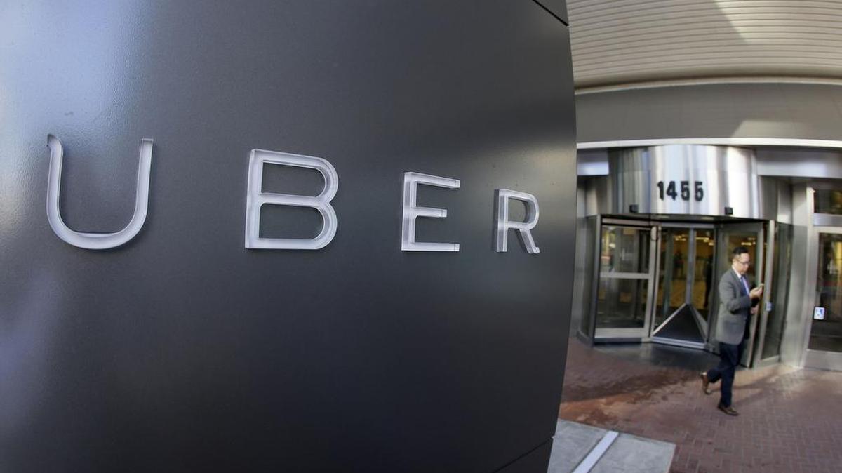 In this Dec. 16, 2014, file photo a man leaves the headquarters of Uber in San Francisco.