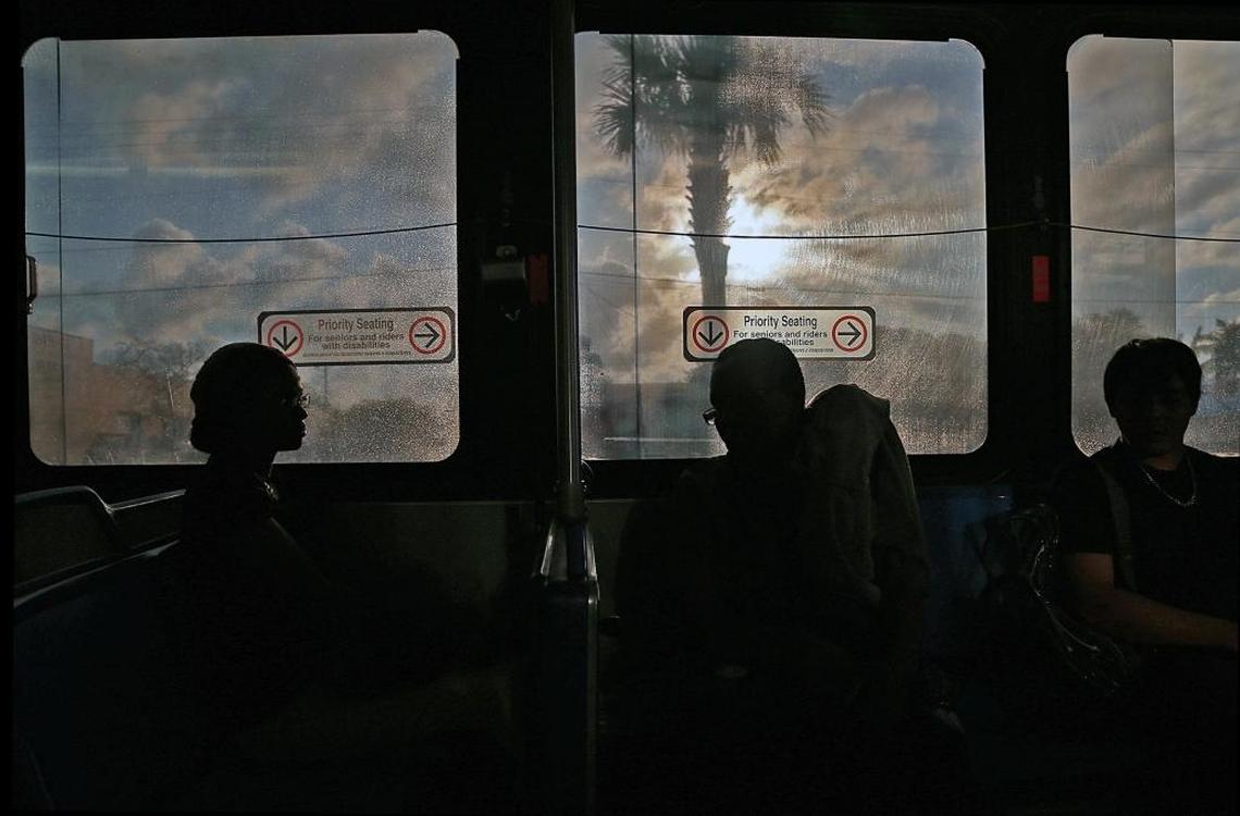 As the sun begins to set, Fontainebleau housekeeper Odelie Paret, center, travels on the last bus of the day as she heads home during her 13.5-mile journey between her job on Miami Beach and her modest two-bedroom apartment in Opa-locka.