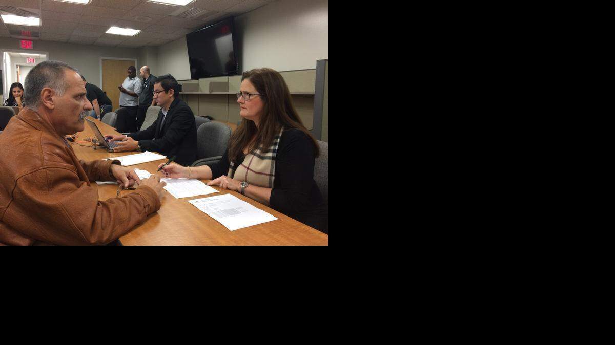 
Wilfredo Roca (L) seeks help filing his taxes from Maria Eisenhart, assistant director at the City of Miami Department of Community & Economic Development and a volunteer in a free county-wide tax assistance program, at City Hall on Thursday. 

