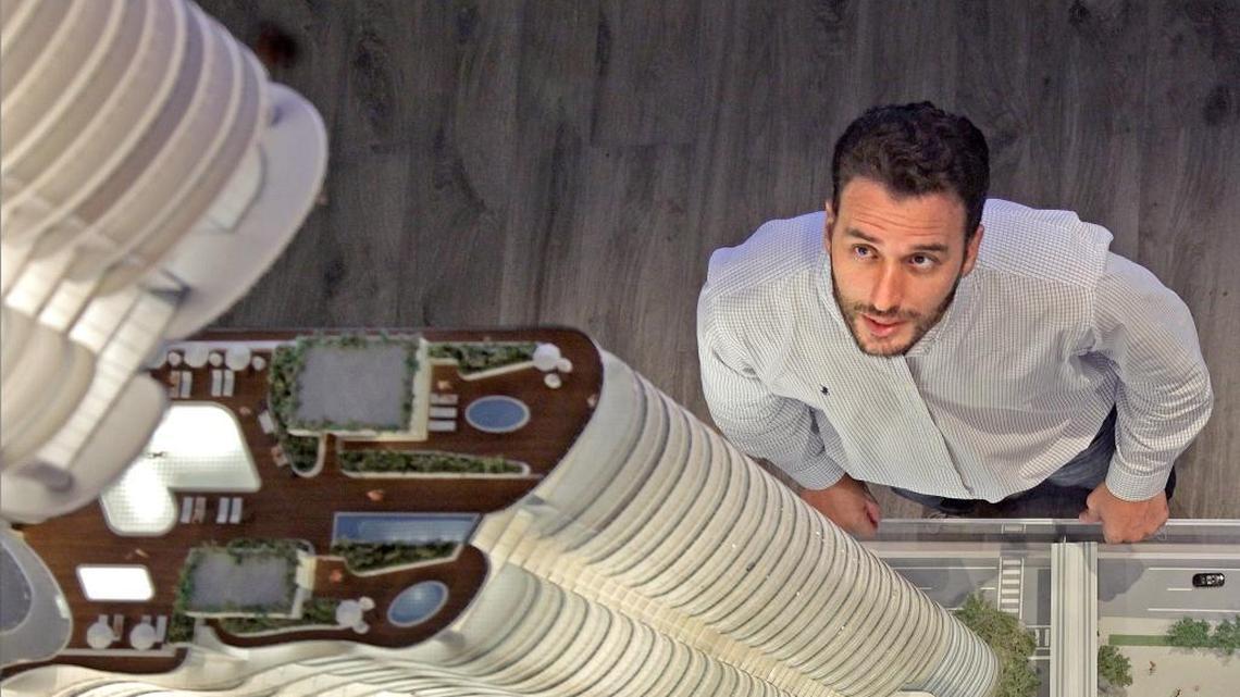 
Condo buyer Simon Pinto looks at the scale model of Brickell Flatiron luxury tower inside the project’s sales gallery in Miami.
