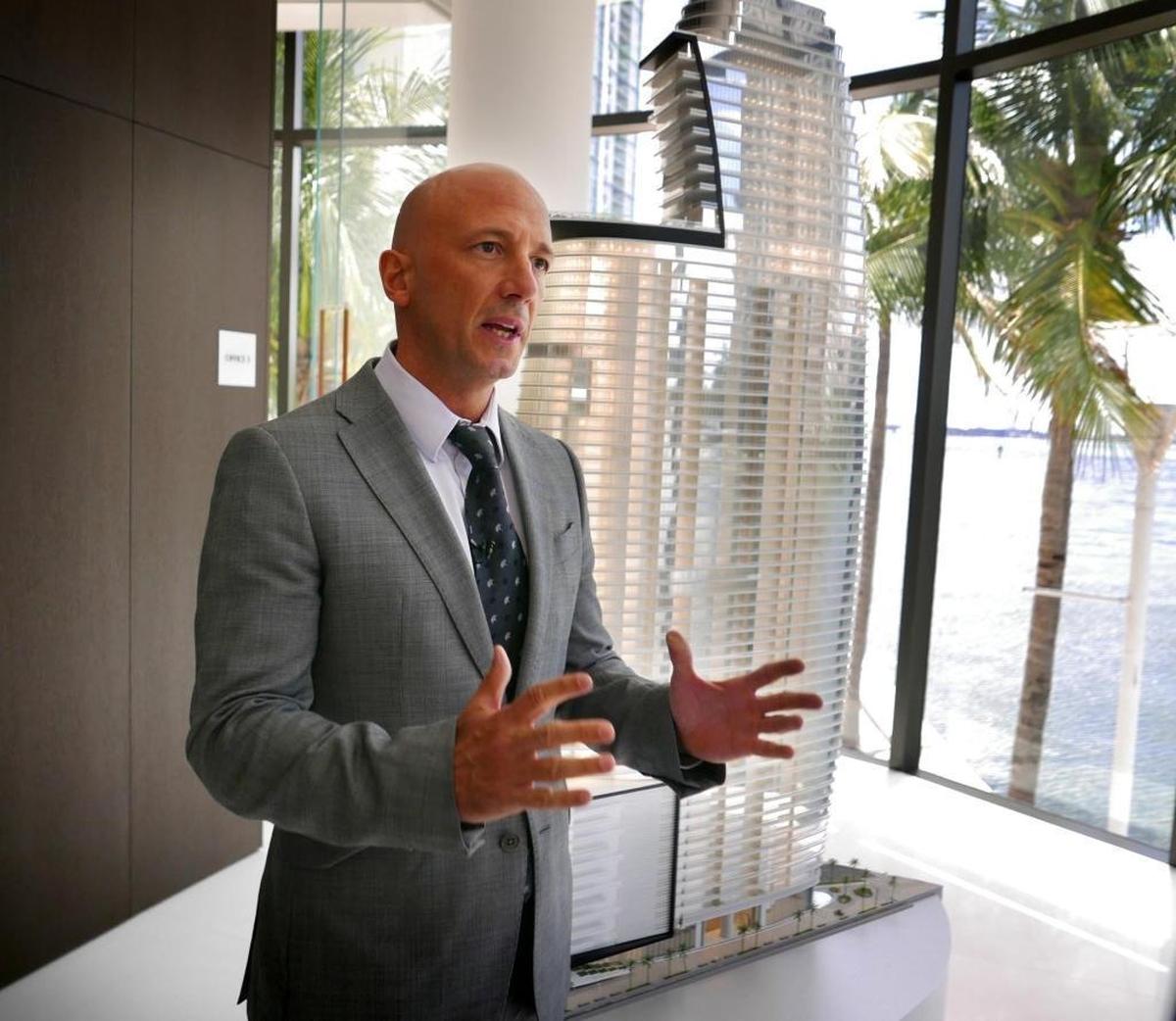 German Coto, who owns the Miami-based real estate firm G&G Business Developments with his mother Gloria, speaks to guests during the opening of the sales center for the 66-story Aston Martin Residences luxury condo tower.