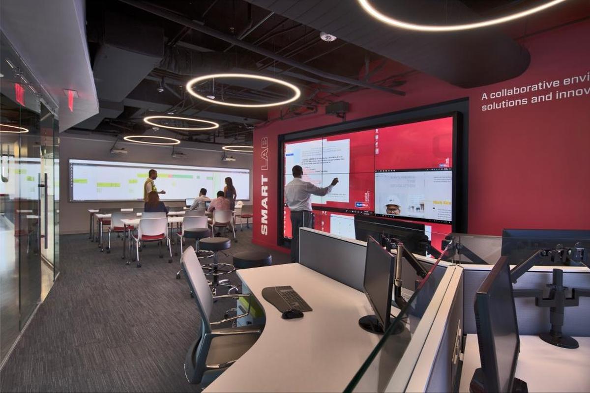 Smart Lab director Lance Dengerud (center) stands before the Data Wall at the new Suffolk Construction Smart Lab that opened this month. The lab allows architects and designers to visualize their projects in immersive 3D, make design decisions and spot potential problems before a single brick has been put into place.