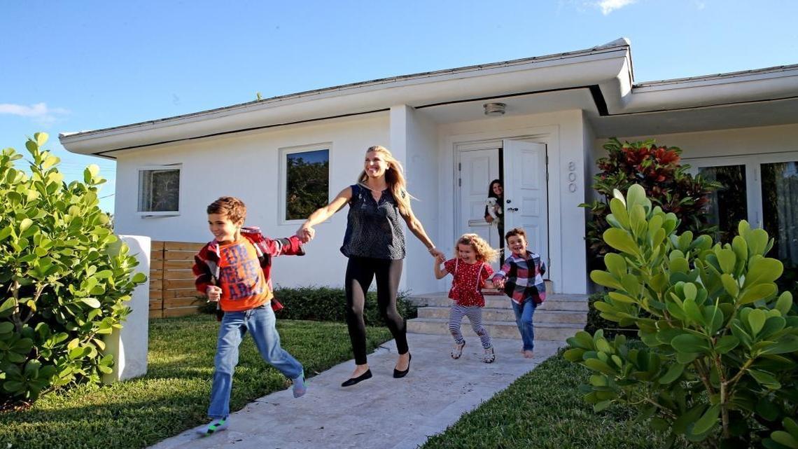 Evie Fernandez, walks with her children Luca 8, Emma 4, and Joaquin 6, at her home in Surfside, a pocket neighborhood popular with families.
