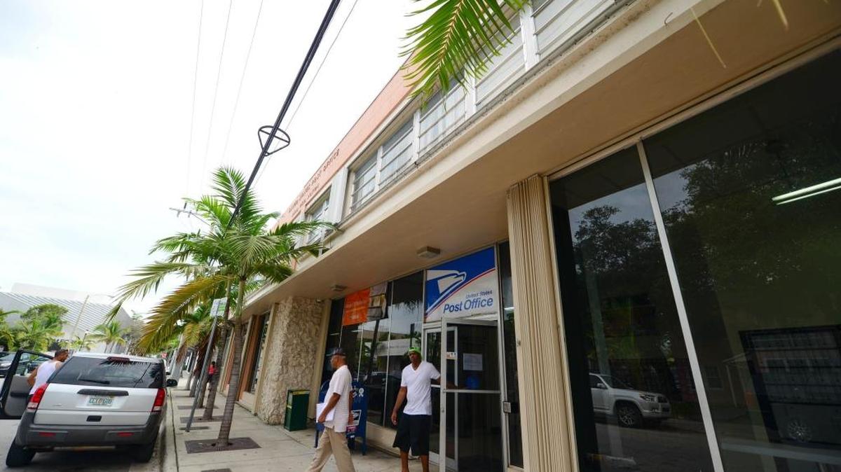 Miami residents Randy Trey, 57, and Tayvion Smart, 32, walk out of the Post Office at 66 NE 39th Street in Miami’s design district on Friday, Dec. 18. The building the Post Office is housed in was sold for about $43.2 million last week to a New York development firm.