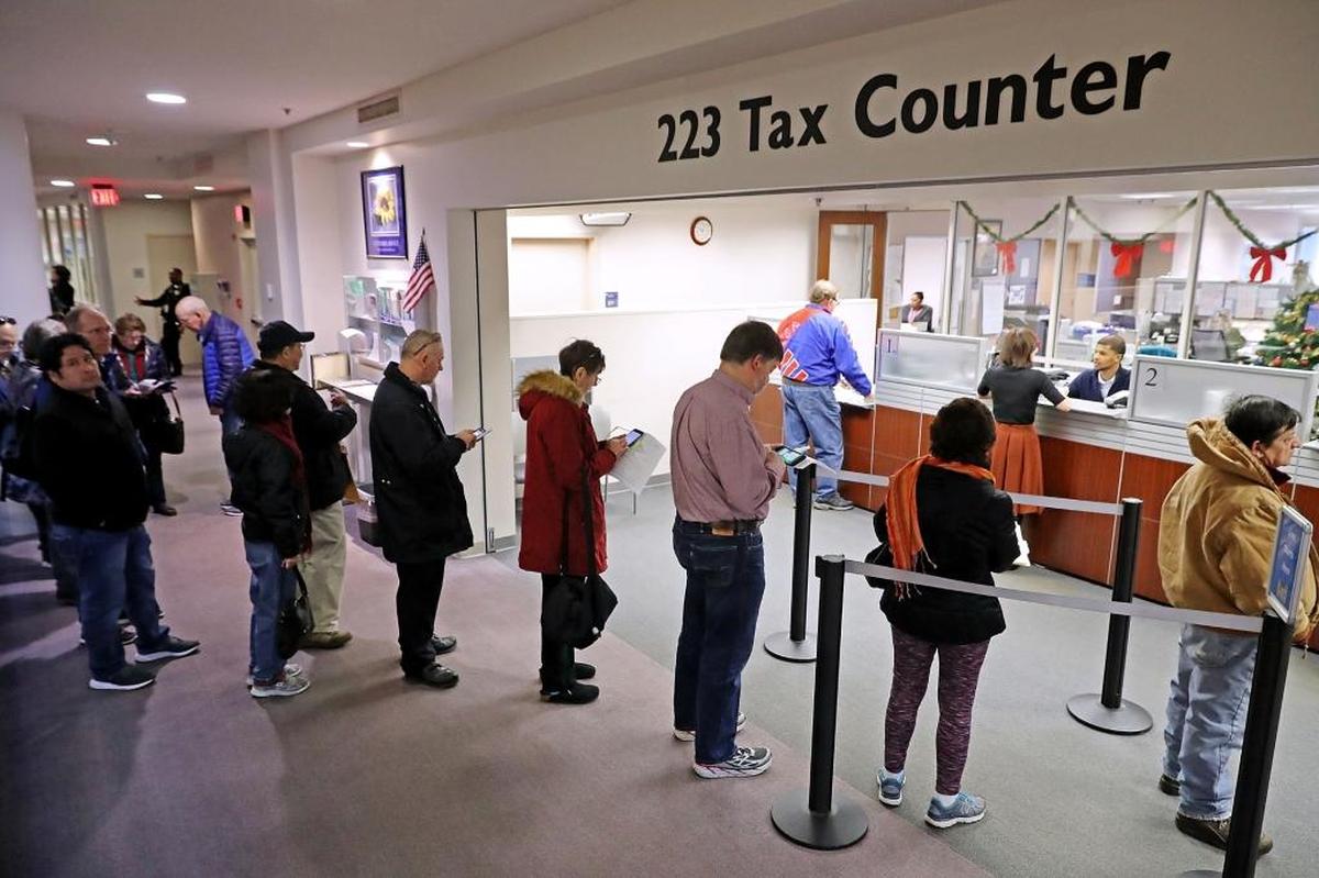Residents wait in line to pay taxes at the Fairfax County Government Center on Thursday, Dec. 28, in Fairfax, Virginia. Many people are pre-paying their 2018 property taxes before the end of the calendar year in an attempt to blunt the effects of the new Republican tax law’s $10,000 cap on deductions for state and local taxes that will disproportionately affect higher-tax, Democratic-leaning states.