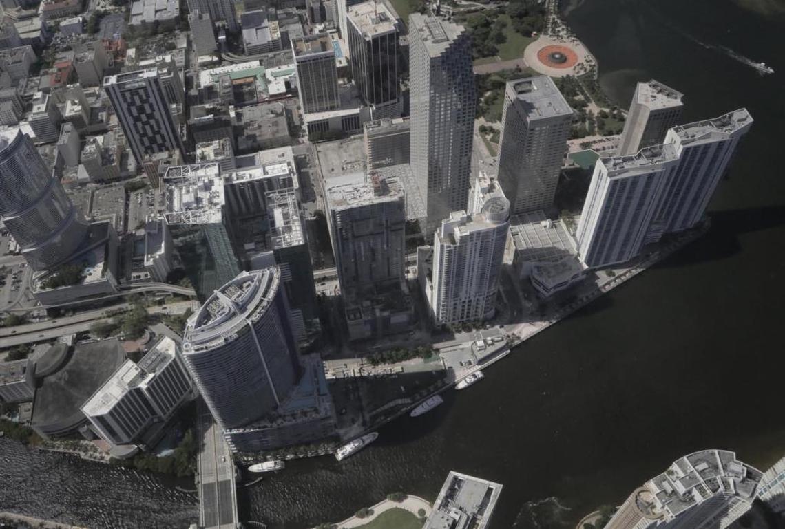 The site of the Aston Martin Residences tower at 300 Biscayne Boulevard Way as seen from the air. A triangular lot located on the mouth of the Miami River, the site is partially shaded in this photo. Its 's located on the lower center of the photo and three boats can be seen docked by the property to the right of the Epic Hotel.