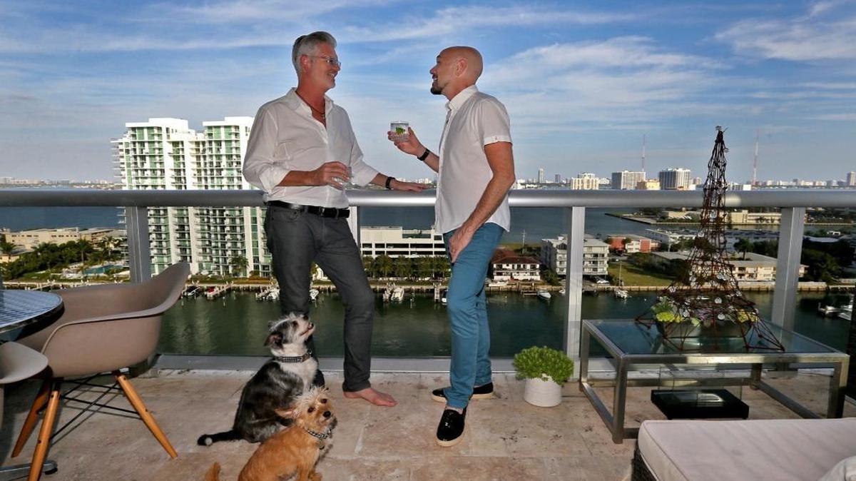 Ritch Holben, left, and Ken De Loreto have a drink on the balcony of their North Bay Village condominium.