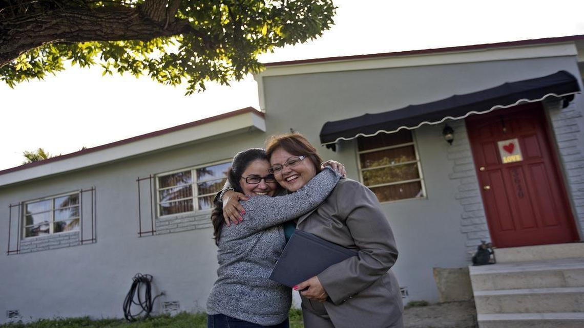 Sissy Esquive, left, gives her Realtor, Nereida Figueroa, a hug outside her Westchester home.