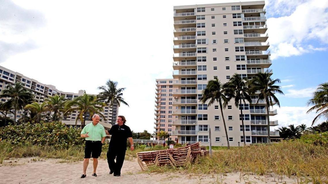 Glenn Collins and real estate broker, Billy Brown, walk behind Collins’ condo on the beach at Sea Ranch Lakes North in Lauderdale-by-the-Sea. Collins lives in the building and has two units for sale.