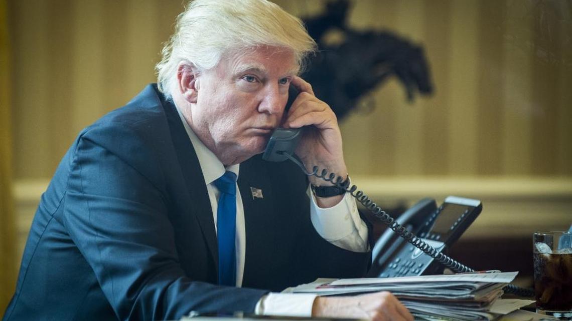 U.S. President Donald Trump speaks on the phone with Vladimir Putin, Russia's president, during the first official phone talks in the Oval Office of the White House in Washington, D.C., U.S., on Saturday, Jan. 28, 2017. Putin and Trump exchanged views on Russia-U.S. relations as Republicans in the U.S. Senate intensify calls to keep sanctions on Russia in place.