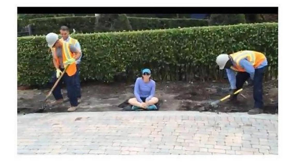 An image from a video shows Dara Clarke sitting while workers build a sidewalk around her near her home at the Island Estates in Aventura in February 2015.